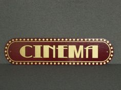 a red and gold cinema sign with the word cinema written on it's side