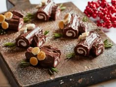 several pieces of chocolate on a cutting board with orange slices and rosemary sprigs