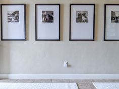 three framed pictures hang on the wall above a tiled floor in a room with white walls