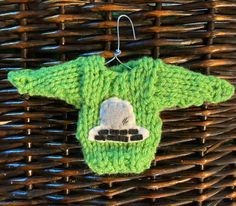 a knitted sweater ornament hanging from a wicker basket