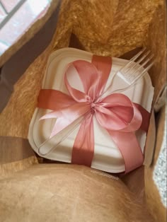 there is a plate with a bow on it and a fork in the box next to it