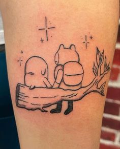 a black and white tattoo of two cats sitting on a tree branch