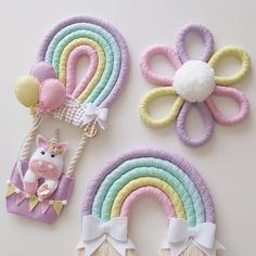 three different colored hair clips with unicorns and rainbows on them next to each other