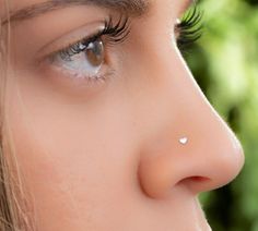 a woman's nose has a tiny white dot on the tip of her nose