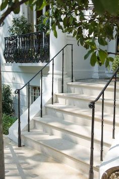 there is a dog that is sitting on the stairs outside this house and it looks like he's waiting for his owner to return