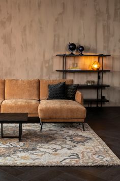 a living room with a couch, coffee table and shelf on the wall behind it