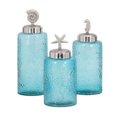 three blue glass containers with silver accents on each one and a starfish on the top