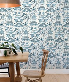 a blue and white wallpaper with birdcages on it in a dining room