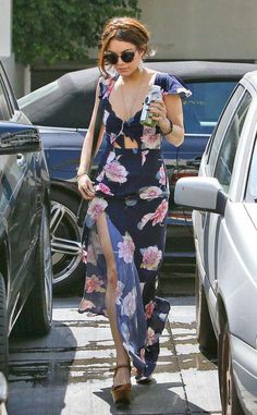 a woman in a floral dress is walking down the street