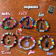 many different bracelets with pictures and name tags attached to them on a wooden table