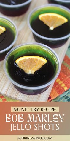 four small bowls filled with black and orange jello shots