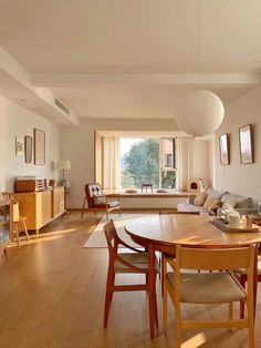 a living room filled with furniture and a wooden table in front of a large window