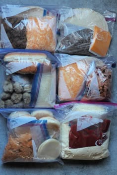 several packaged food items sitting in plastic bags on the ground, including bread, cheese, and other foods