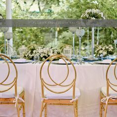 the tables are set with white linens and gold chairs for an elegant wedding reception