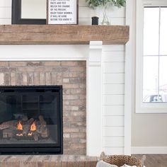 a fire place in a living room next to a fireplace with pictures on the mantle