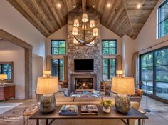 a living room filled with furniture and a fire place in front of a large window