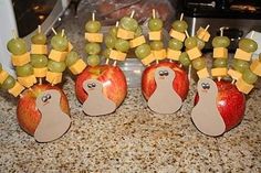 apples and grapes are arranged in the shape of hedgehogs with cheese on them