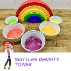 there is a woman standing in front of bowls with different colored paints on it and the words skittles density tower