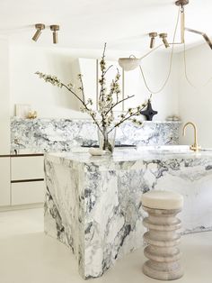 a kitchen with marble counter tops and stools