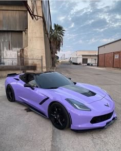 a purple sports car parked in front of a building