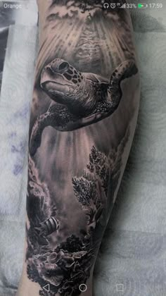 a man's arm with a turtle and sea creatures tattoo on the left forearm