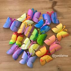 colorful paper butterflies are arranged on a wooden surface with string attached to the top one