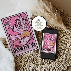 two playing cards sitting on top of a table next to a cell phone with the text howdy 21 printed on it