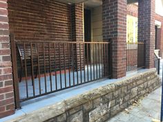 a brick building with a metal fence on the front and side of it that is next to a sidewalk