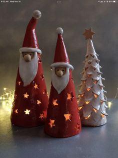 three small christmas trees with santa hats and stars on them, sitting next to each other