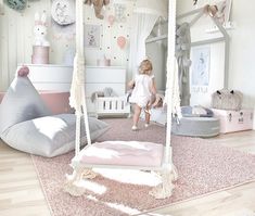 a child's bedroom with pink and white accessories on the floor, including a swing bed