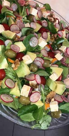 a salad with cheese, radishes, lettuce and other veggies