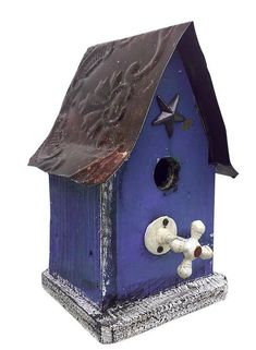 a blue birdhouse with a dog and star decoration on it's roof, against a white background