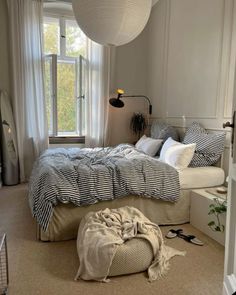 a bedroom with a bed, window and rugs on the floor in front of it