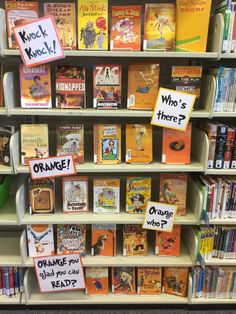 there are many children's books on display in the library, including orange and yellow