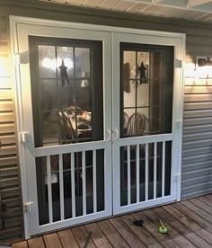 two glass doors on the outside of a house with wood flooring and metal siding