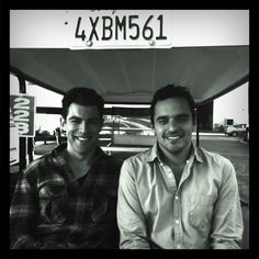 two men sitting next to each other in front of a gas station with the words 4x bm521 on it