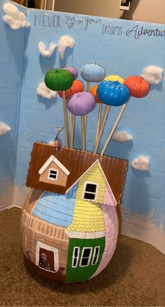 a paper mache house with balloons in the air