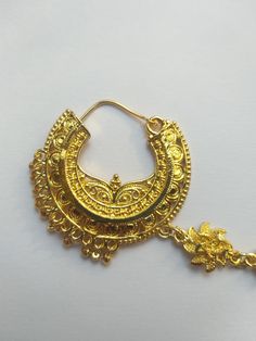 a pair of gold earrings on a white surface