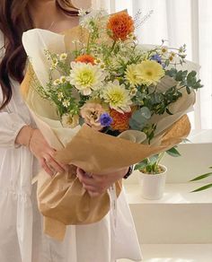 a woman holding a bouquet of flowers in her hands