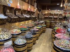 a room filled with lots of different types of candies in glass domes and wooden barrels