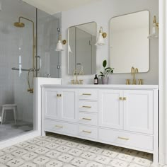 a bathroom with white cabinets and gold handles