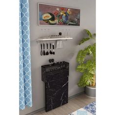 a black stove top oven sitting next to a potted plant and painting on the wall