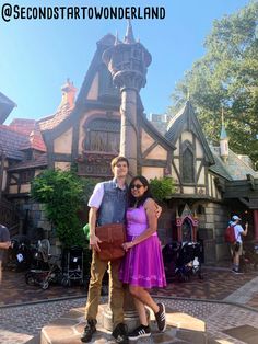 a man and woman standing in front of a castle