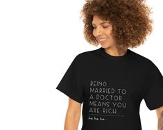 a woman wearing a t - shirt that says being married to a doctor means you are rich