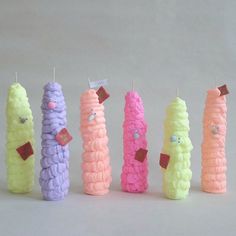 five different colored candles are lined up in the shape of candy cornucons with faces on them