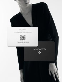 a woman in black dress holding up a business card