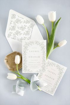 the wedding stationery is laid out with tulips