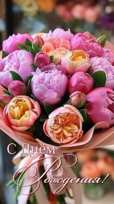 a bouquet of pink and yellow flowers with the words congratulations written in russian on it