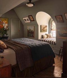 a bed room with a neatly made bed and pictures hanging on the wall above it