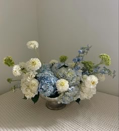 a vase filled with white and blue flowers